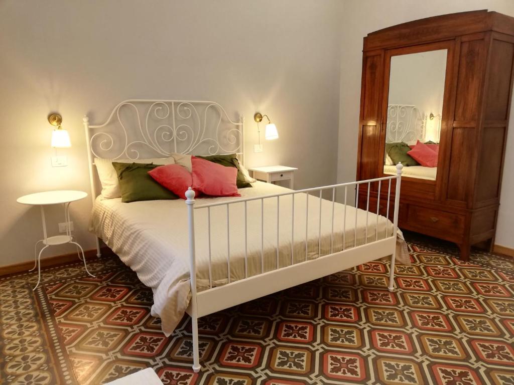 比萨Casa Ridolfi Holiday Home -Una terrazza sui giardini di Pisa的卧室配有白色的床和镜子