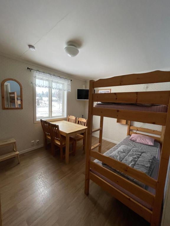 特克斯福什Turistgården Töcksfors的客房设有一张桌子和一张双层床。