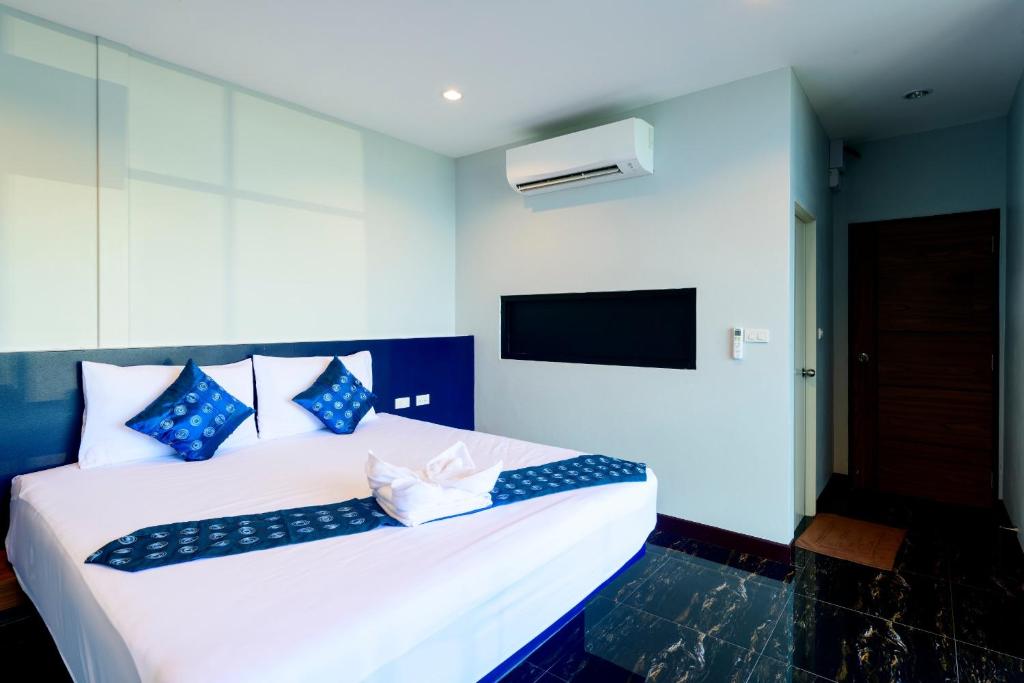 Ban Khlong Lat Bua KhaoSkyline Resort的卧室配有带蓝色枕头的大型白色床