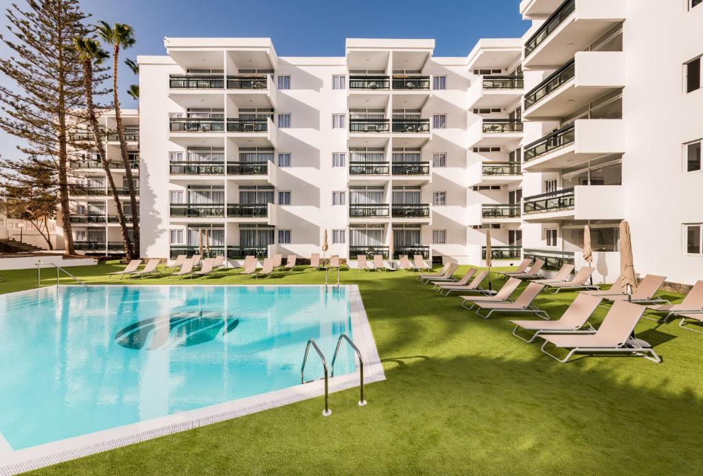 英格兰海滩Roca Verde - Playa del Inglés的一座带游泳池的公寓大楼的图片
