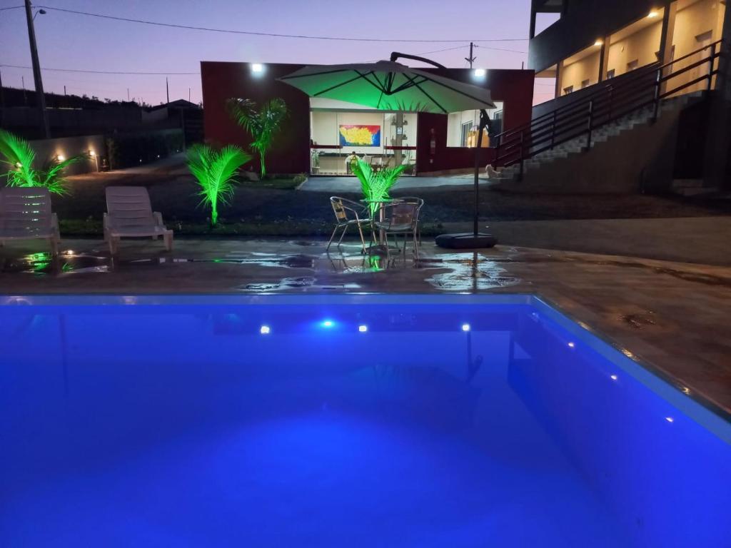 卡皮托利乌Pousada Morada dos Pássaros的游泳池(带绿伞)