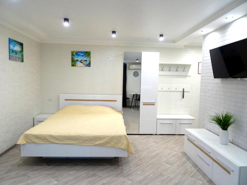 克洛佩夫尼茨基Apart Gagarina 7的一间白色卧室,配有床和一间浴室