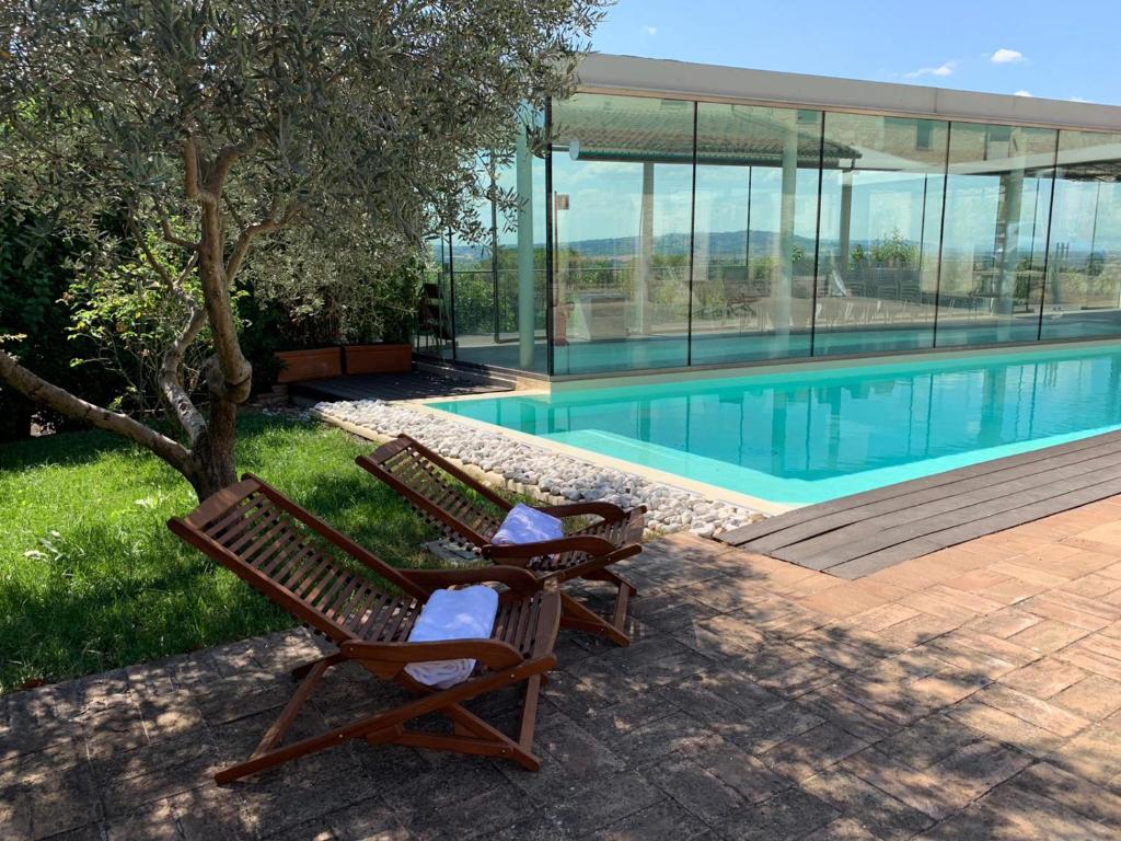 特雷维Corte Fratini Appartamenti的游泳池旁的两把椅子