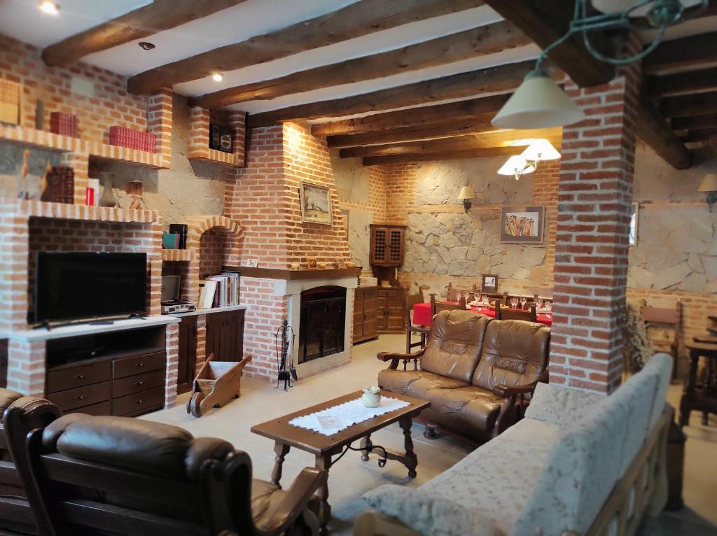 贝拉约斯Casa Rural Puerta de Castilla的带沙发和壁炉的客厅
