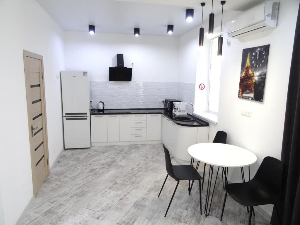 克洛佩夫尼茨基Apart Poltavska的厨房配有桌椅和冰箱。
