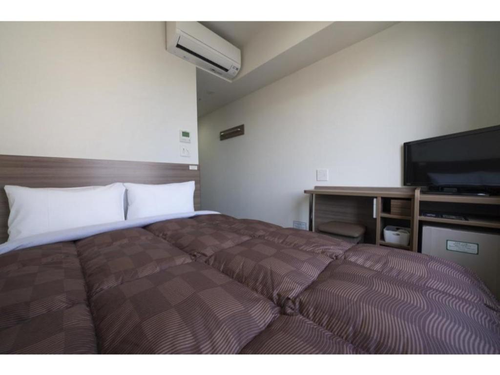 福冈R&B Hotel Hakata Ekimae 2 - Vacation STAY 40724v的一间卧室配有一张床和一台平面电视