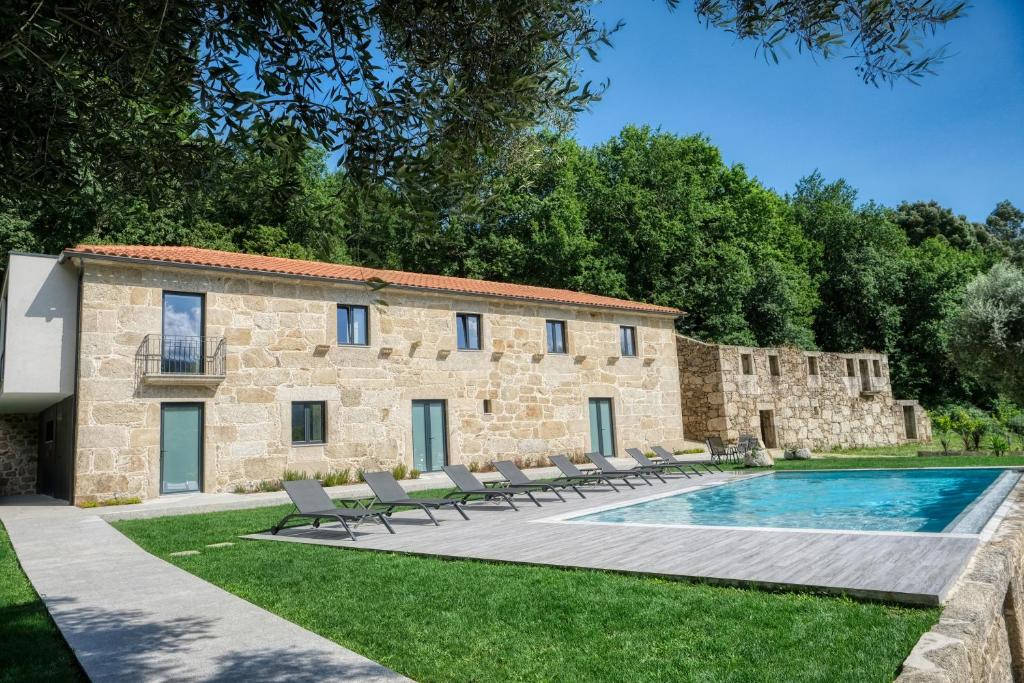 阿尔库什迪瓦尔德维什Quinta da Mourinha的一座古老的石头建筑,设有游泳池和椅子