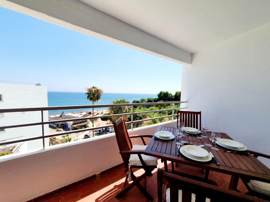 卡博皮诺Marbellamar Seaviews的一间设有桌子并享有海滩美景的用餐室