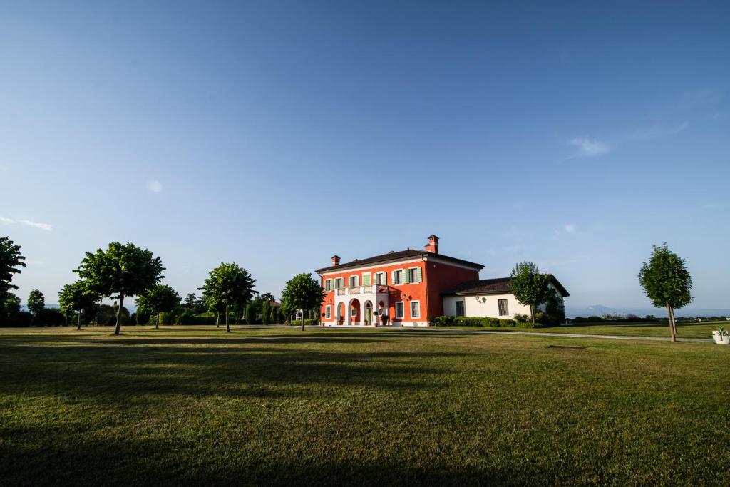 代森扎诺-德尔加达Villa San Pietro的一座大型的红色和白色房子,有大片草地