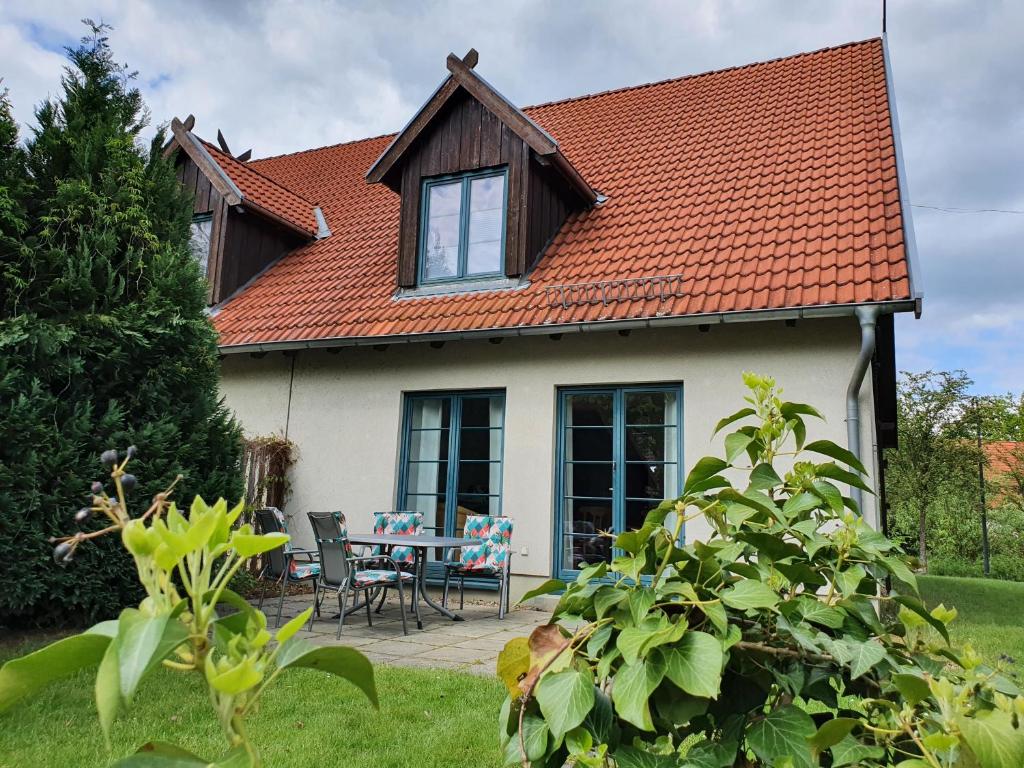 布尔格Ferienhaus Igel的一座带橙色屋顶、桌子和椅子的房子