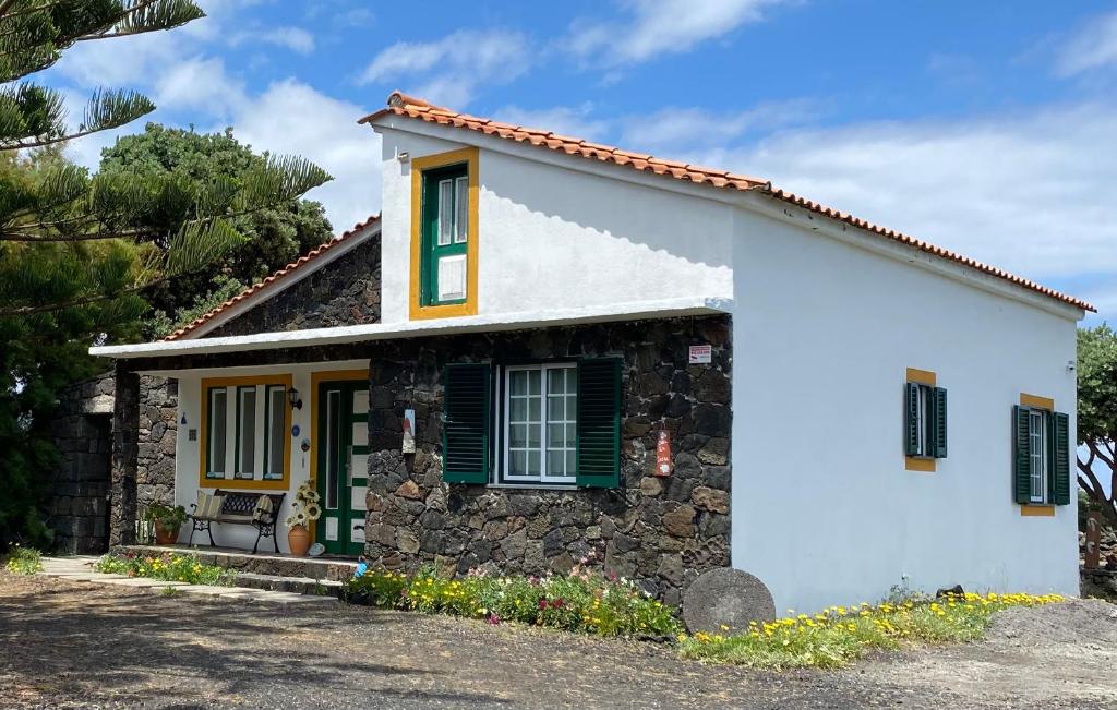 马达莱纳Casa da Costa的白色的小房子,设有绿色百叶窗
