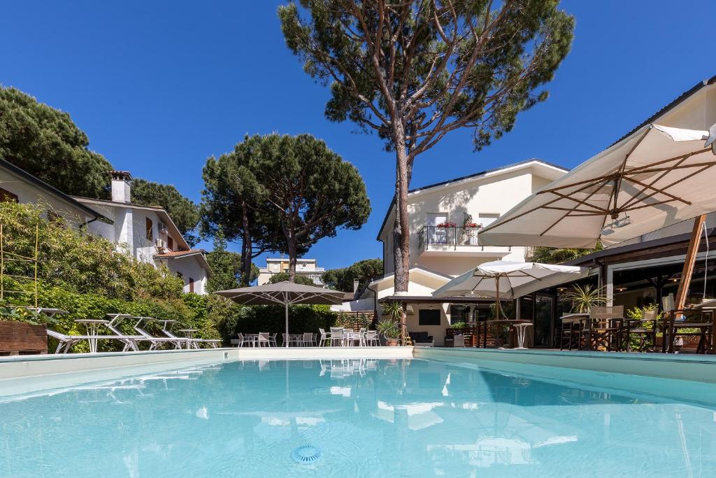 玛里纳罗米亚塔温尼塔酒店的一个带遮阳伞的游泳池和一座建筑