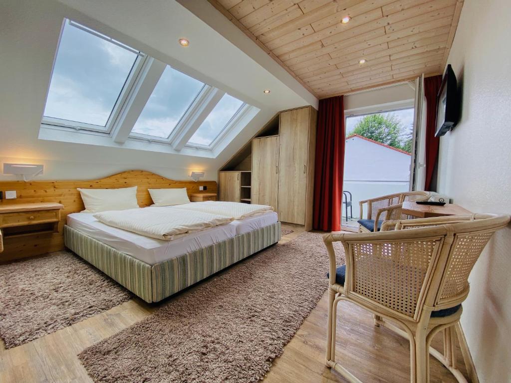 瓦尔德克Landhotel Edersee的一间卧室配有一张床、一张桌子和一把椅子