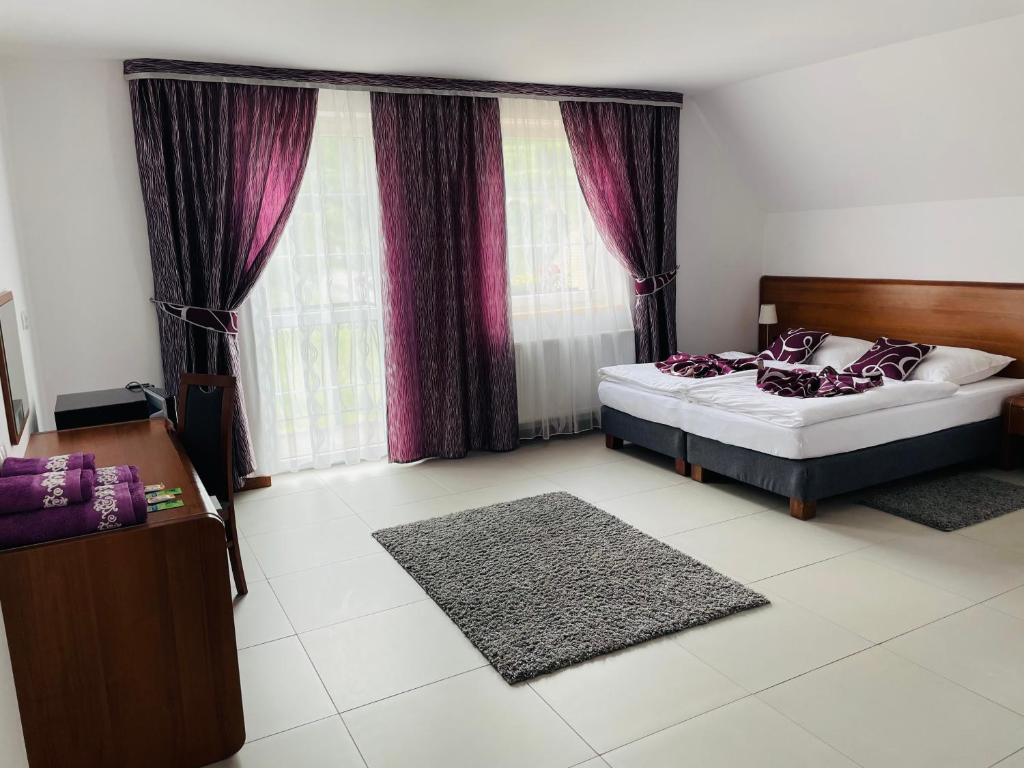 库多瓦-兹德鲁伊Pod Orłem的一间卧室配有一张床和一个带紫色窗帘的窗户