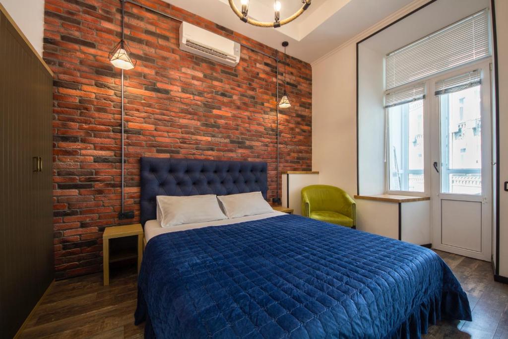 基辅DayFlat Apartments on Mykhailivs'ka的一间卧室设有蓝色的床和砖墙