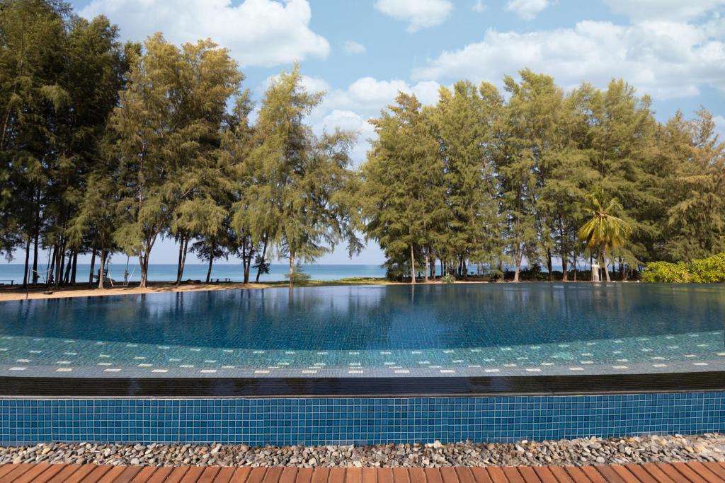 迈考海滩Splash Beach Resort, Maikhao Phuket - SHA Extra Plus的一座树木环绕的游泳池