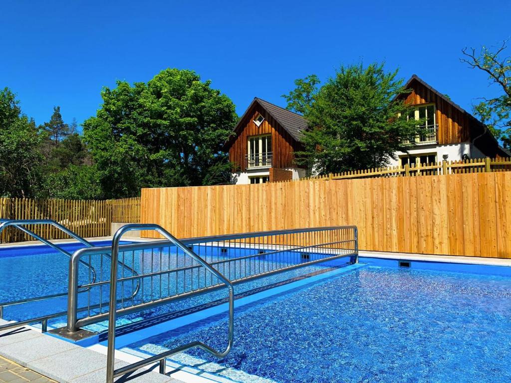 奎德林堡哈茨家庭俱乐部假日公园的木质围栏前的游泳池