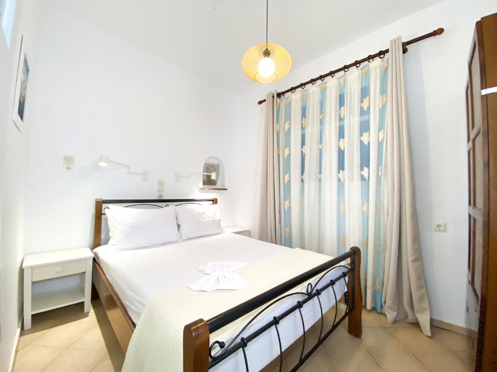 阿吉奥斯普罗科皮奥斯迪娜纳克索斯公寓 的一间卧室配有一张带白色床单的床和一扇窗户。