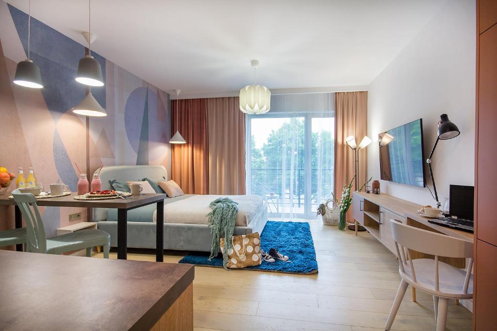 科沙林W&K Apartments - Joy Suite的一间卧室配有一张床和一张书桌,另一间卧室配有一张书桌。