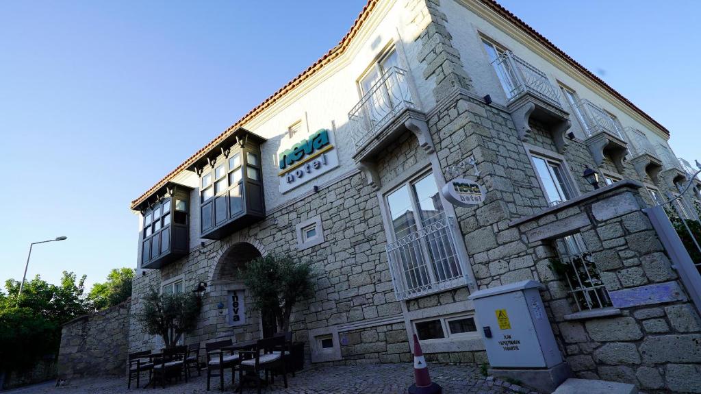 阿拉恰特Neva Hotel Alaçatı的一座石头建筑,旁边标有标志