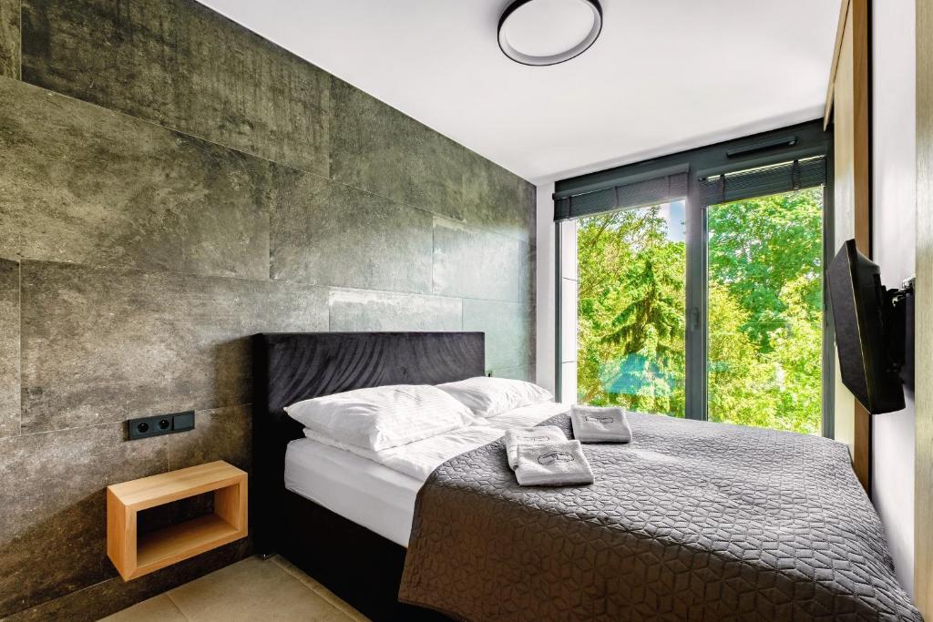 卢布林Apartamenty Premium NJ Lublin Centrum Basen & SPA的一间卧室配有一张带混凝土墙的床
