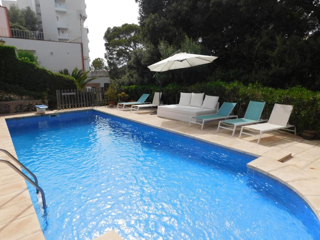卡拉加尔达纳Apart.Can Pons,con piscina, a 50 de la playa的一个带躺椅和遮阳伞的游泳池