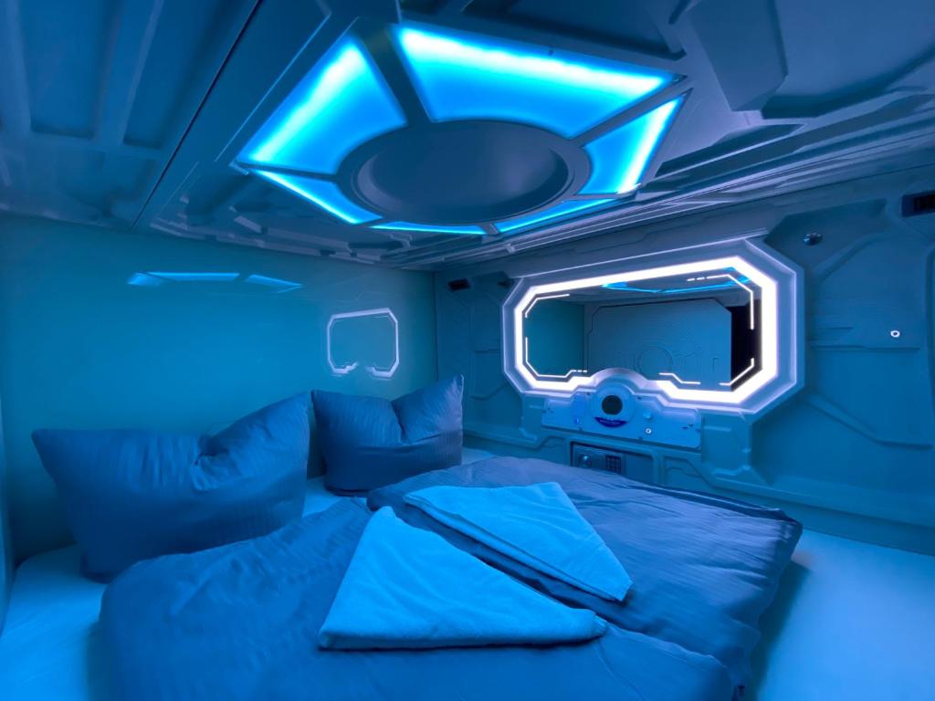 柏林Space Night Capsule Hostel的蓝色的房间,配有床和电视