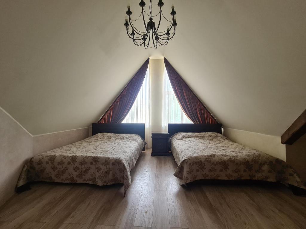 VabalninkasMeldynas的带大窗户的客房内的两张床