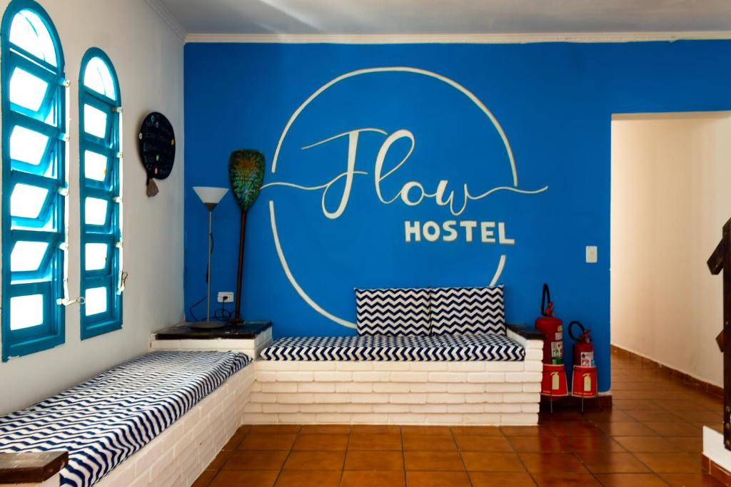 朱奎Flow Hostel Juquehy的一间有蓝墙的房间,上面有阅读欢乐旅馆标志