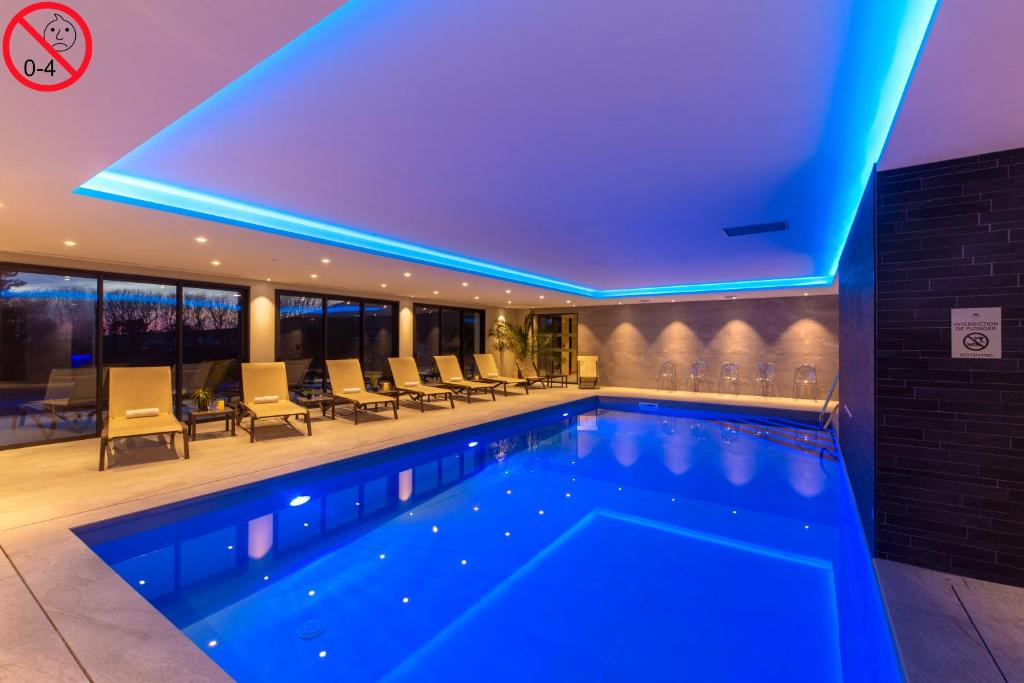 埃斯卡勒Hôtel L'Escale - Piscine & SPA的蓝色灯光的酒店游泳池