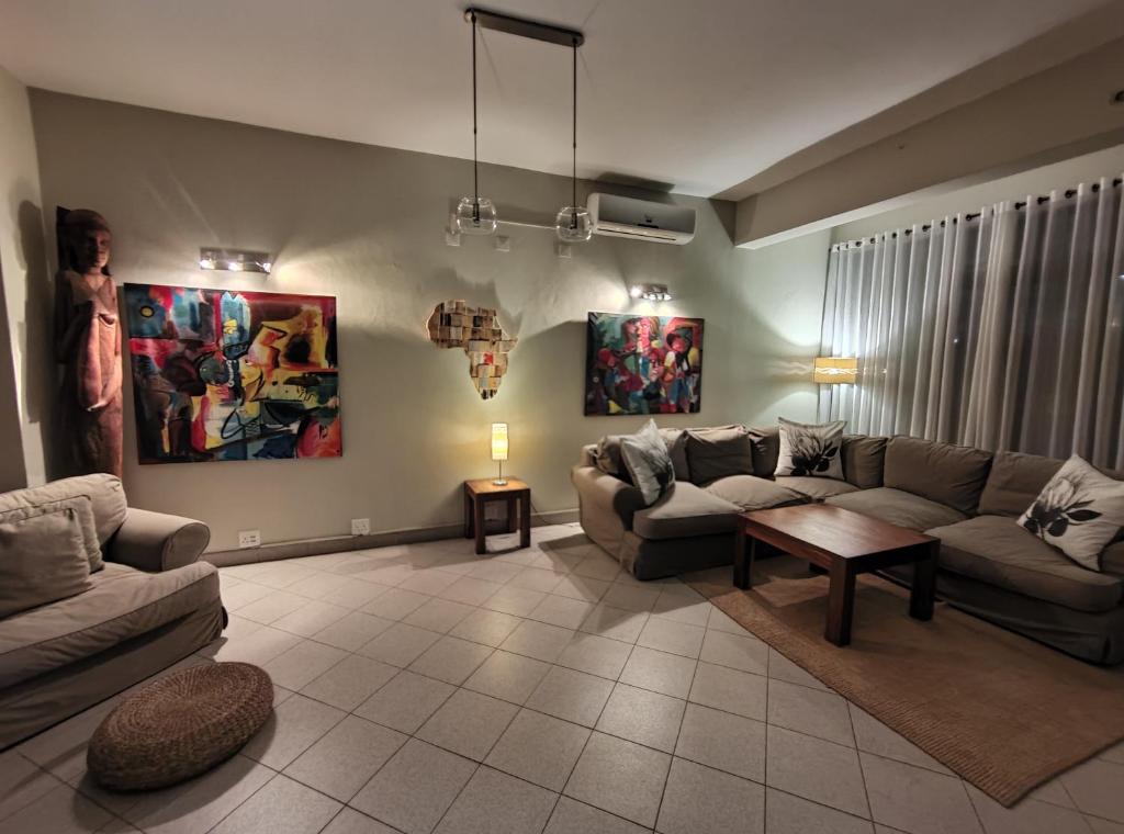 马普托Sundown Guest House Maputo的客厅配有两张沙发和一张桌子