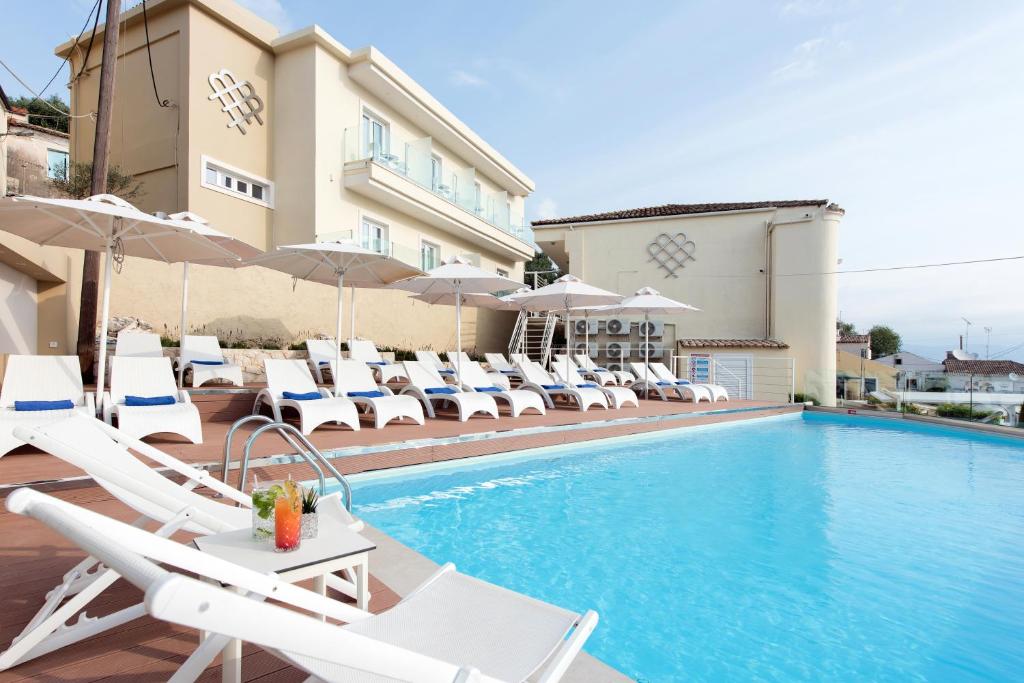 卡西奥皮Melina Bay Boutique Hotel的一个带躺椅的游泳池和一间酒店