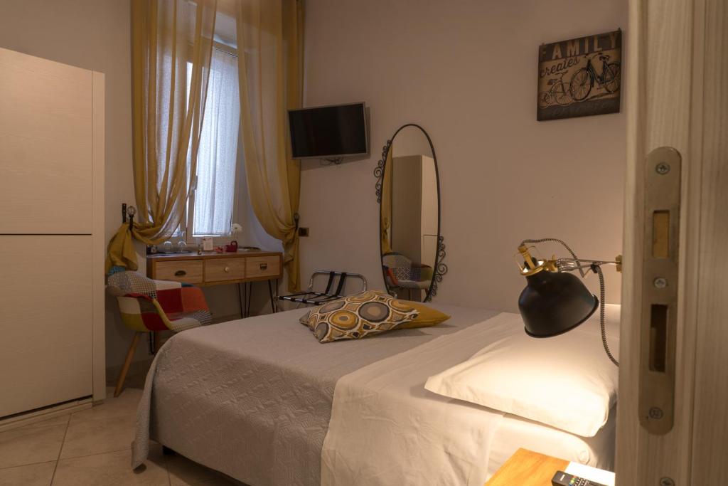 那不勒斯B&B Pantarei Napoli的一间卧室配有一张床、镜子和一张桌子