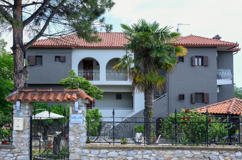 尼基季Villa Elli的一座白色的房子,有门和棕榈树
