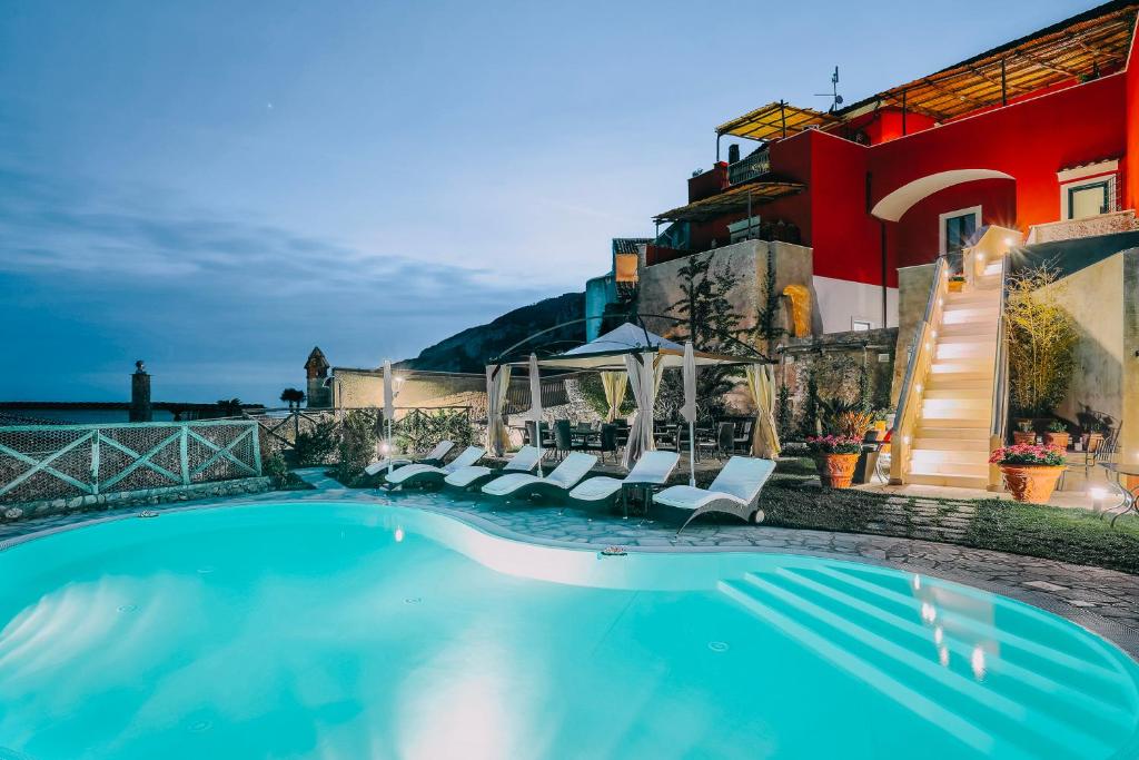 斯卡拉帕斯卡尔宫酒店的一座带椅子的游泳池以及一座建筑