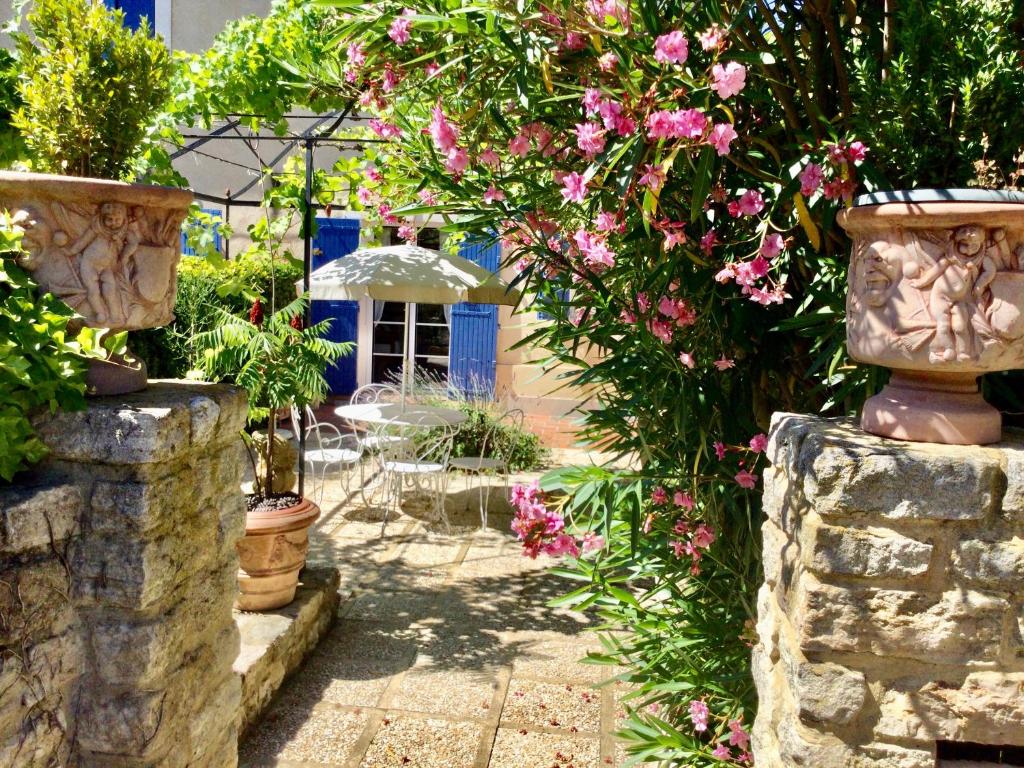 卡庞特拉le vieux pont的一座花园,花园内种有粉红色的花卉和石墙