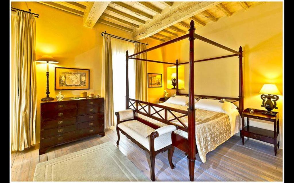 切托纳la locanda di anita的一间卧室配有四柱床和一张书桌