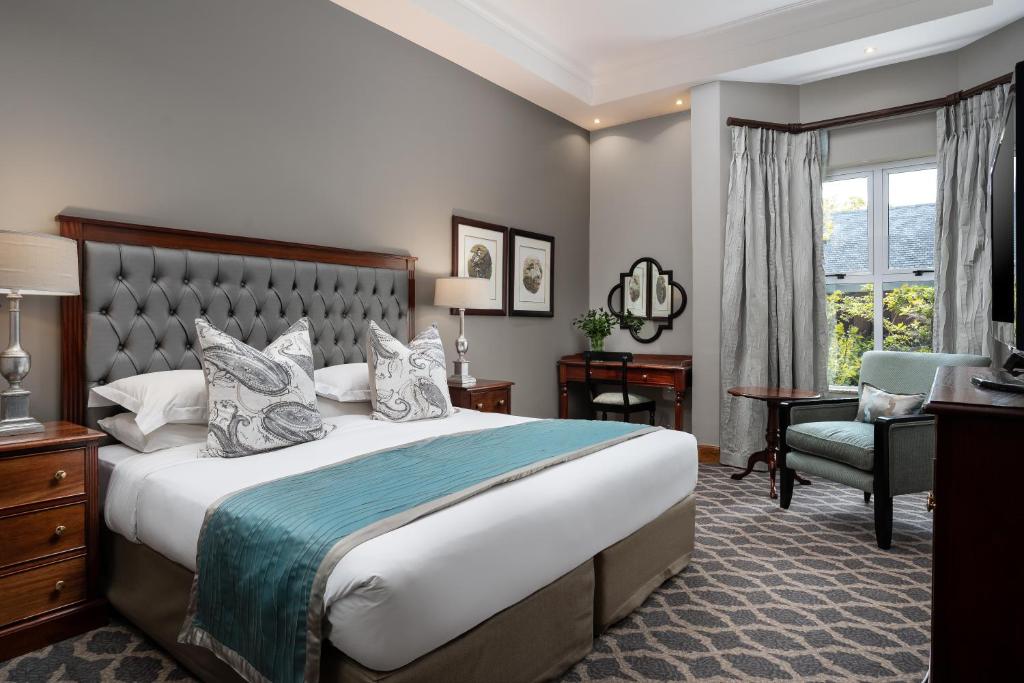 约翰内斯堡Premier Hotel Quatermain的酒店客房带一张大床和一把椅子