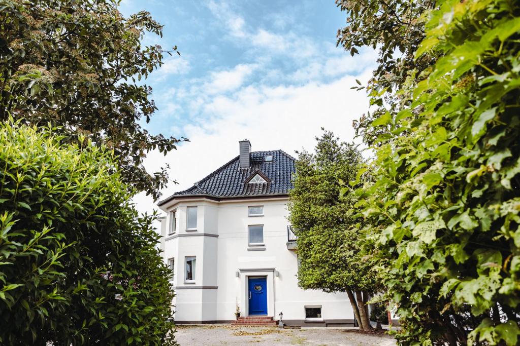 格拉尔-米里茨DAS STRANDGLÜCK - Villa und Mee(h)r的白色的房子,有蓝色的门和树木