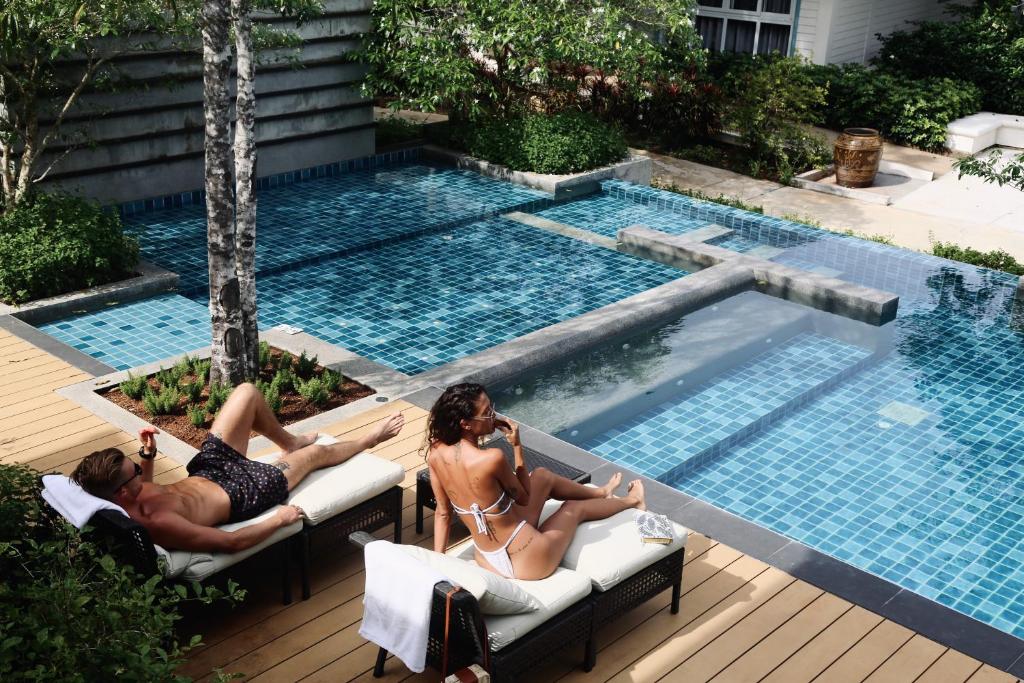 班奥南矛Na Sook Wellness Resort的一群人在游泳池边躺在椅子上