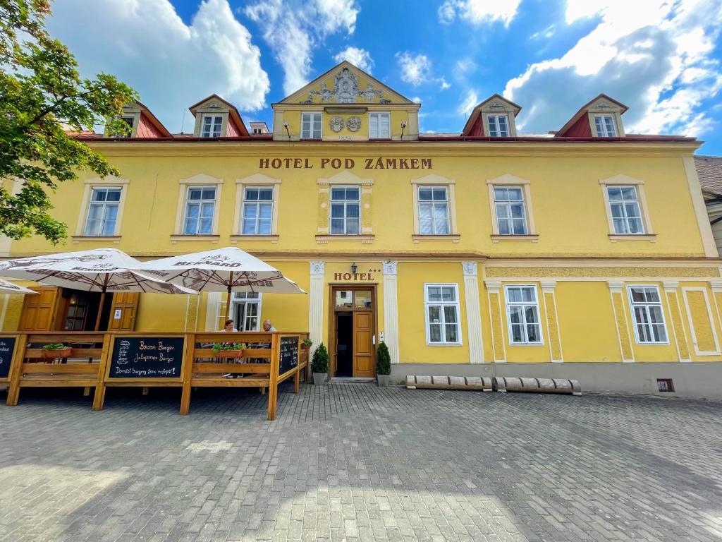 迪耶河畔弗拉诺夫Hotel Pod Zámkem的前面有雨伞的黄色建筑