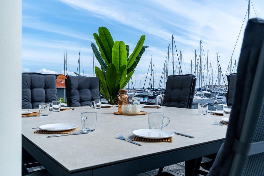 奥德多普Appartement in Zeeland - Kabbelaarsbank 2C - Port Marina Zélande - Ouddorp - not for companies的码头顶部的桌子,上面有盘子和玻璃杯