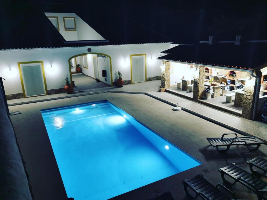 雷根古什-迪蒙萨拉什Casinhas da Avó Aura的夜间在房子里的一个游泳池