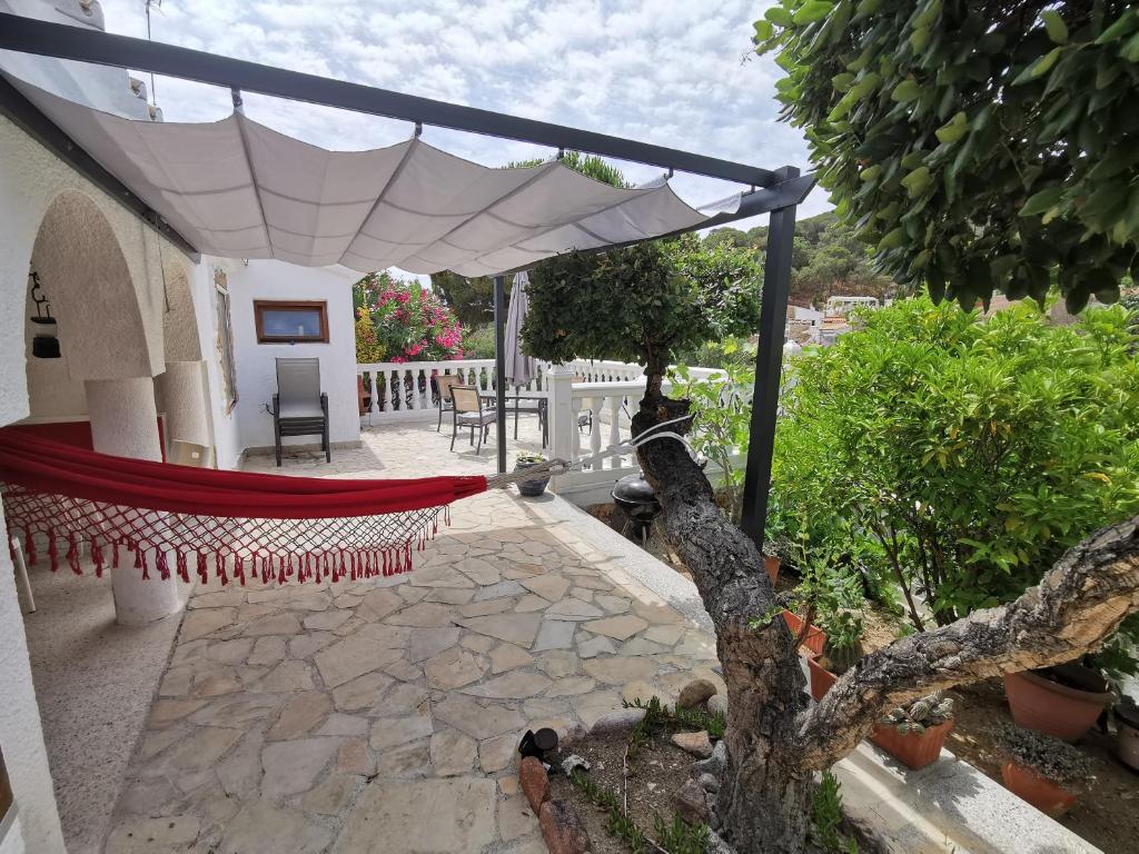 滨海托萨Casa Morisca的一个带吊床的白色遮阳伞下庭院