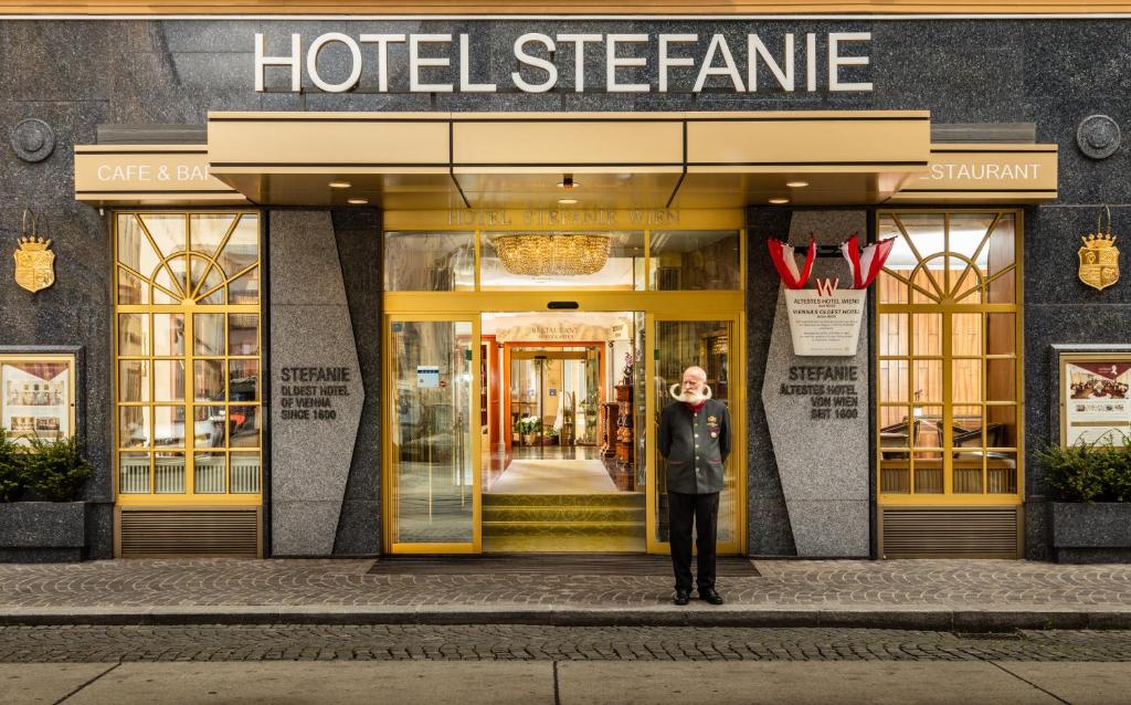 维也纳Hotel Stefanie - VIENNA'S OLDEST HOTEL的站在酒店商店前的人