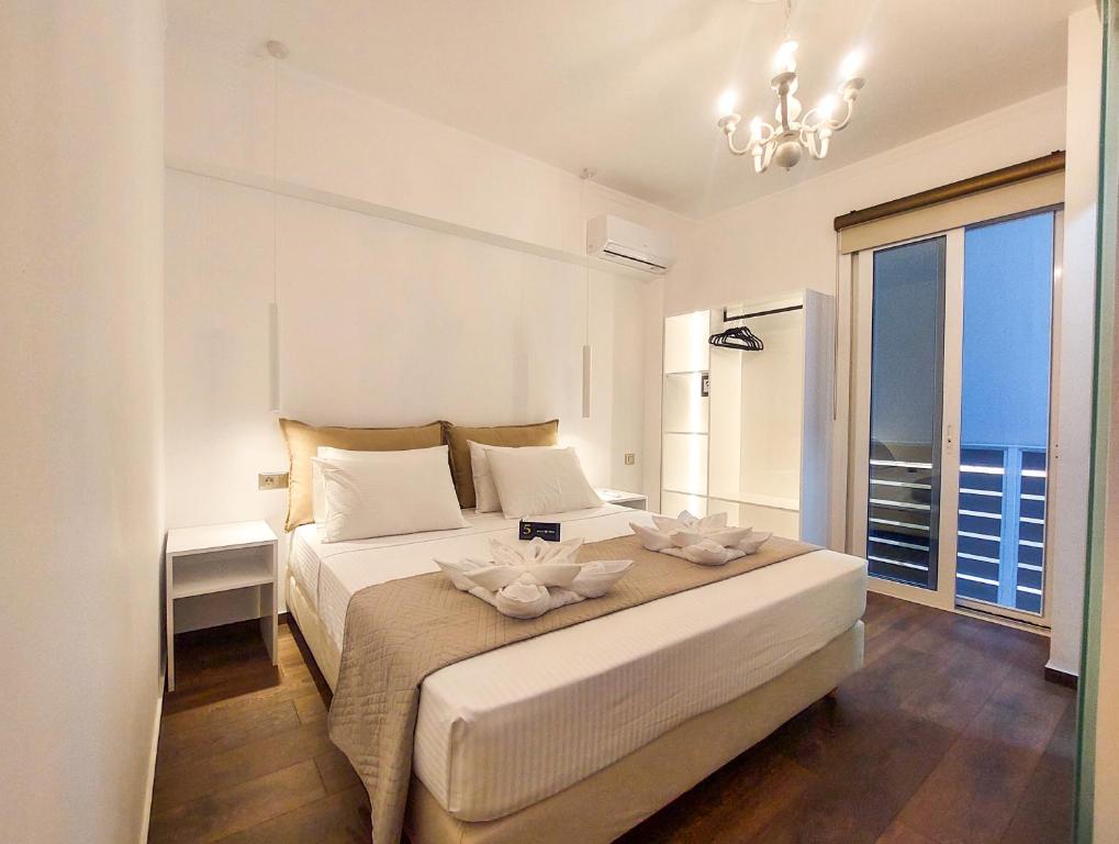 阿尔戈斯托利翁Polymnia Luxury Apartments Argostoli的白色的卧室设有一张大床和一个窗户