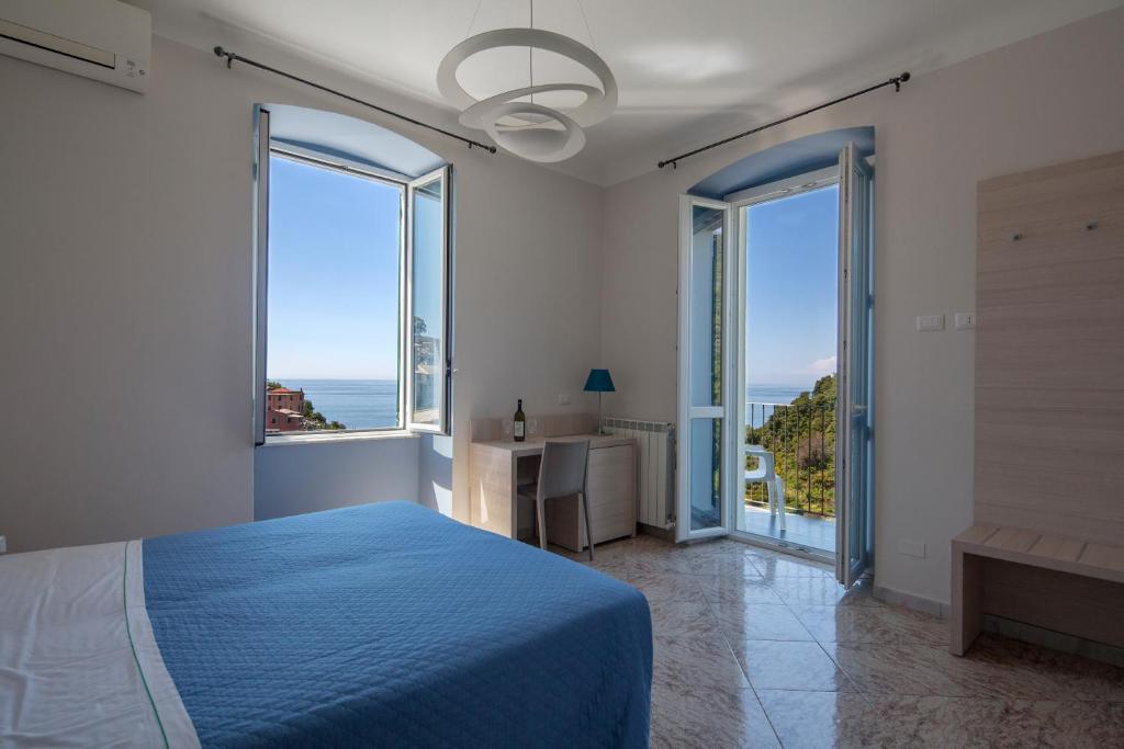 克里日亚Cecio 5 Terre Rooms的一间卧室设有蓝色的床和大窗户