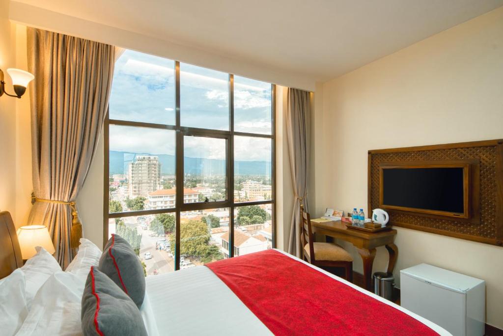 莫希Kibo Palace Hotel Moshi的酒店客房设有一张床和一个大窗户