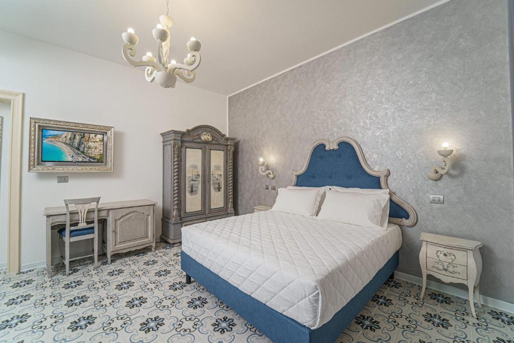 特罗佩阿The Gentleman of Tropea的一间卧室配有蓝色的床和吊灯。
