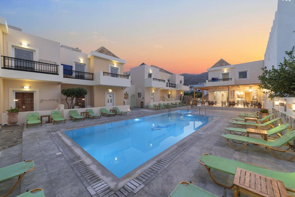 伊罗达Olive Grove Apartments的度假村内的大型游泳池,配有躺椅